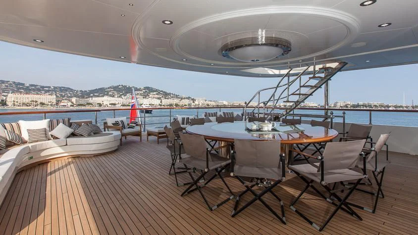 a room with a table chairs and a view of a city aboard INCAL Yacht for Sale