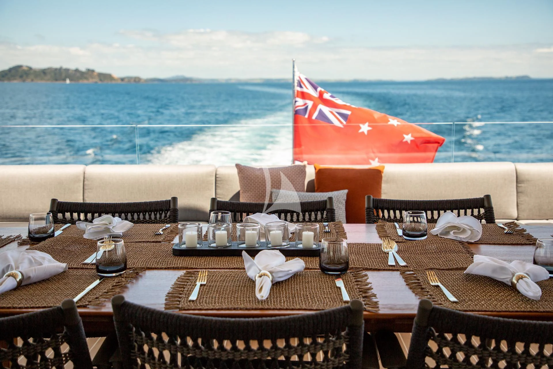 a table with chairs and a flag on it aboard RUA MOANA Yacht for Sale