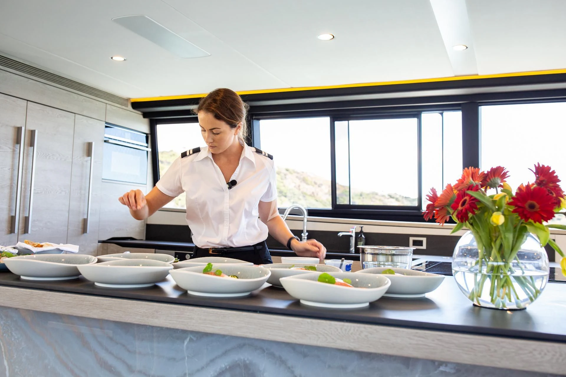 a woman in a kitchen preparing food aboard RUA MOANA Yacht for Sale
