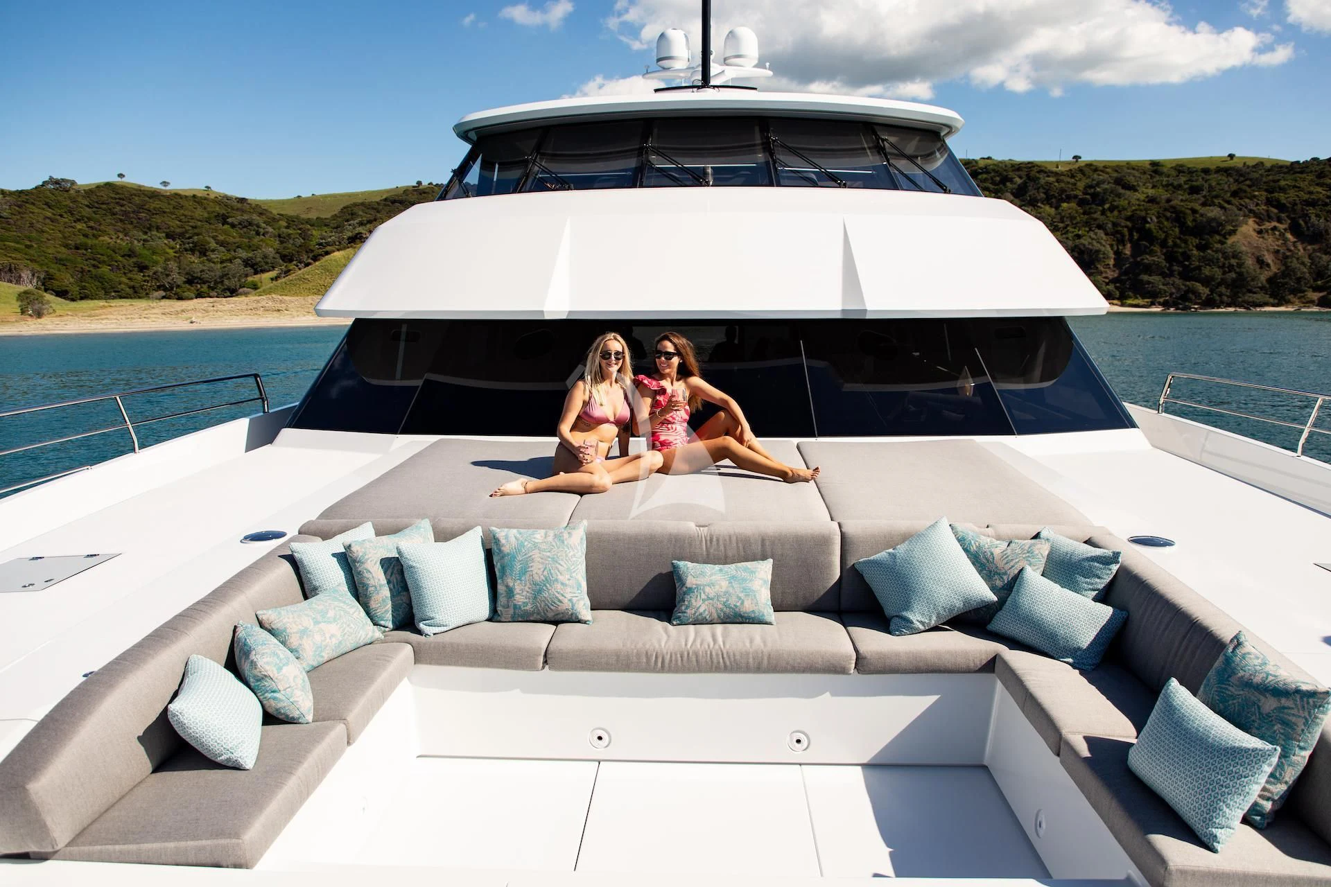 a couple of women sitting on a white yacht on a sunny day aboard RUA MOANA Yacht for Sale