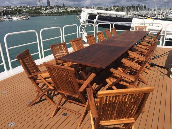 a table and chairs on a deck overlooking a body of water aboard PURSUIT Yacht for Sale