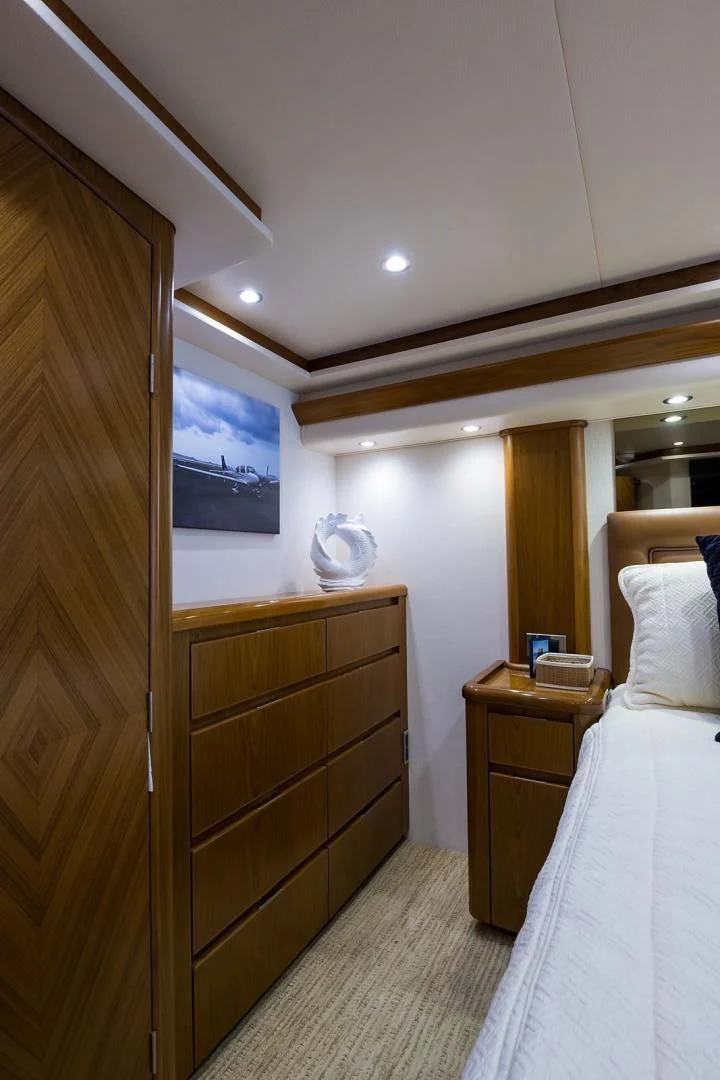 a bedroom with a bed and a dresser aboard LAST CALL Yacht for Sale