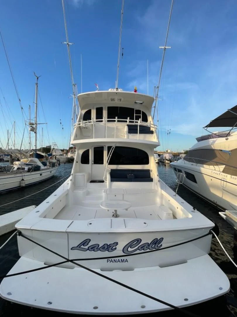 a white boat in a harbor aboard LAST CALL Yacht for Sale