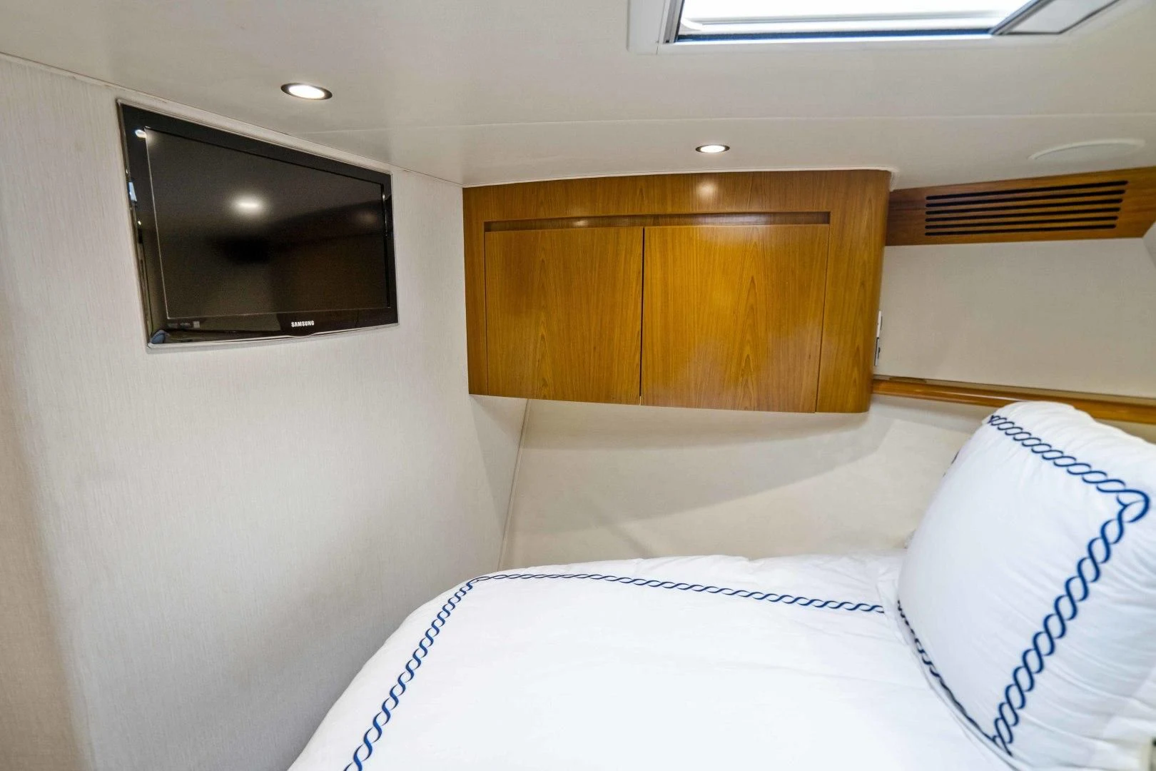 a room with a bed and a television aboard LAST CALL Yacht for Sale