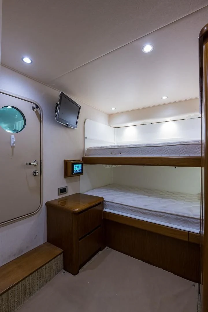 a room with a bed and a tv on the wall aboard LAST CALL Yacht for Sale