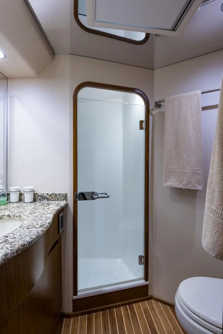 a bathroom with a glass shower door aboard LAST CALL Yacht for Sale