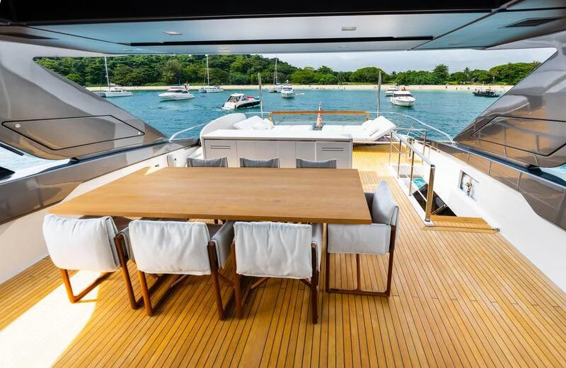 a table and chairs on a deck overlooking a body of water aboard DA MOON Yacht for Sale