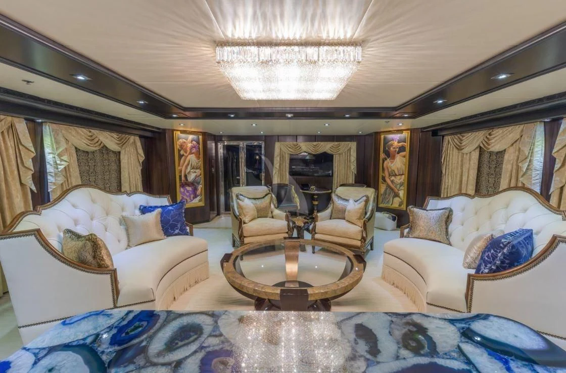 a living room with a large blue rug and white couches aboard GRADE I Yacht for Charter