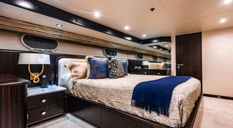 a bed with a blue sheet aboard GRADE I Yacht for Charter