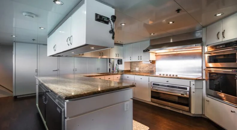 a kitchen with white cabinets aboard GRADE I Yacht for Charter