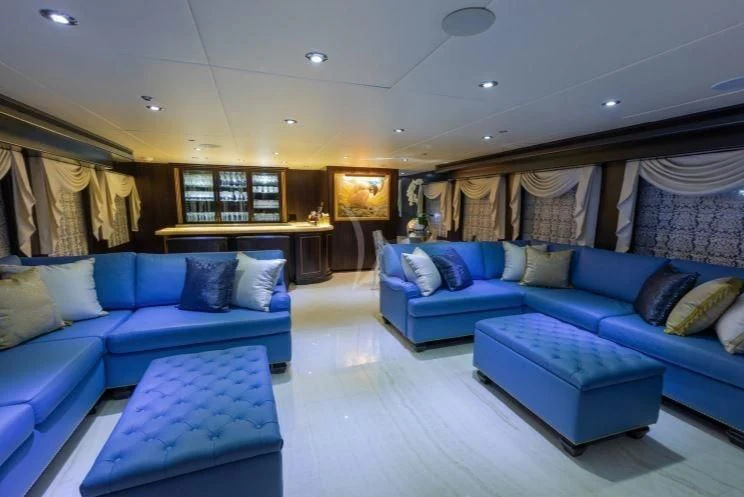 a living room with blue couches aboard GRADE I Yacht for Charter