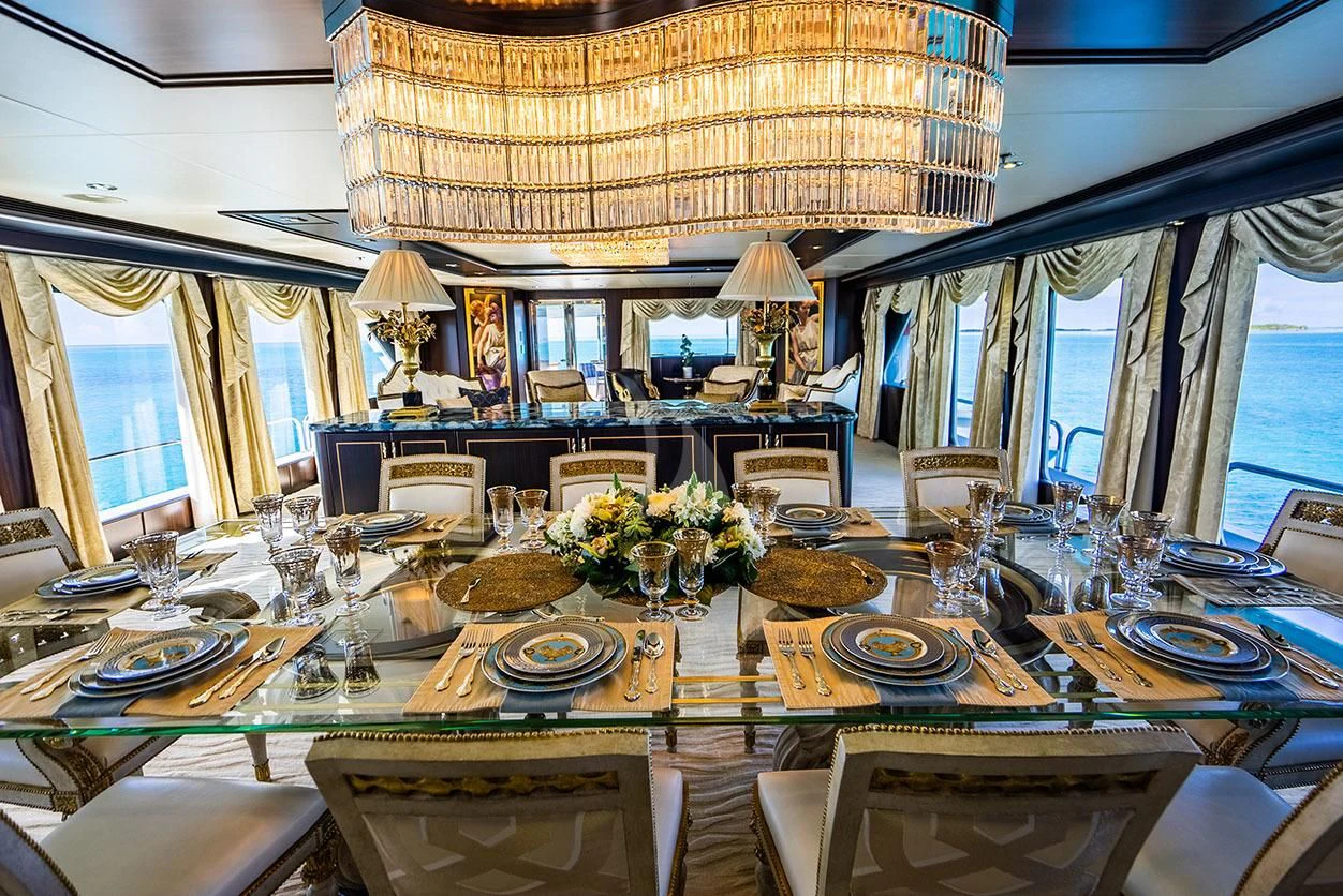 a large dining room with a large table set for a formal dinner aboard GRADE I Yacht for Charter