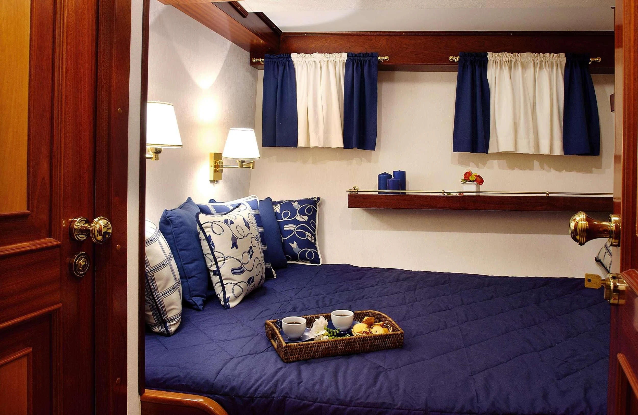 a bed with blue sheets and pillows aboard LIANA H Yacht for Charter