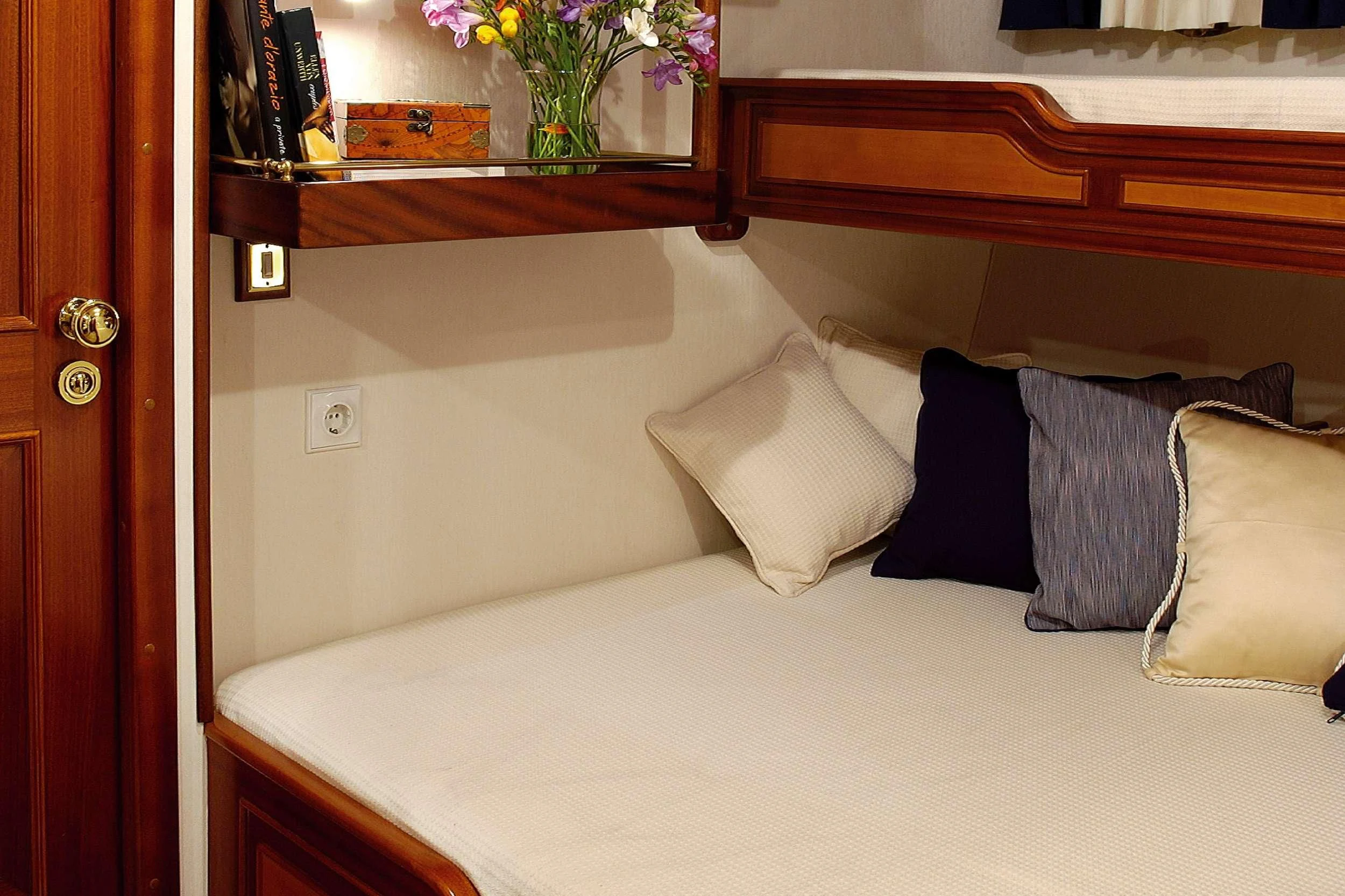 a bed with pillows and a shelf aboard LIANA H Yacht for Charter