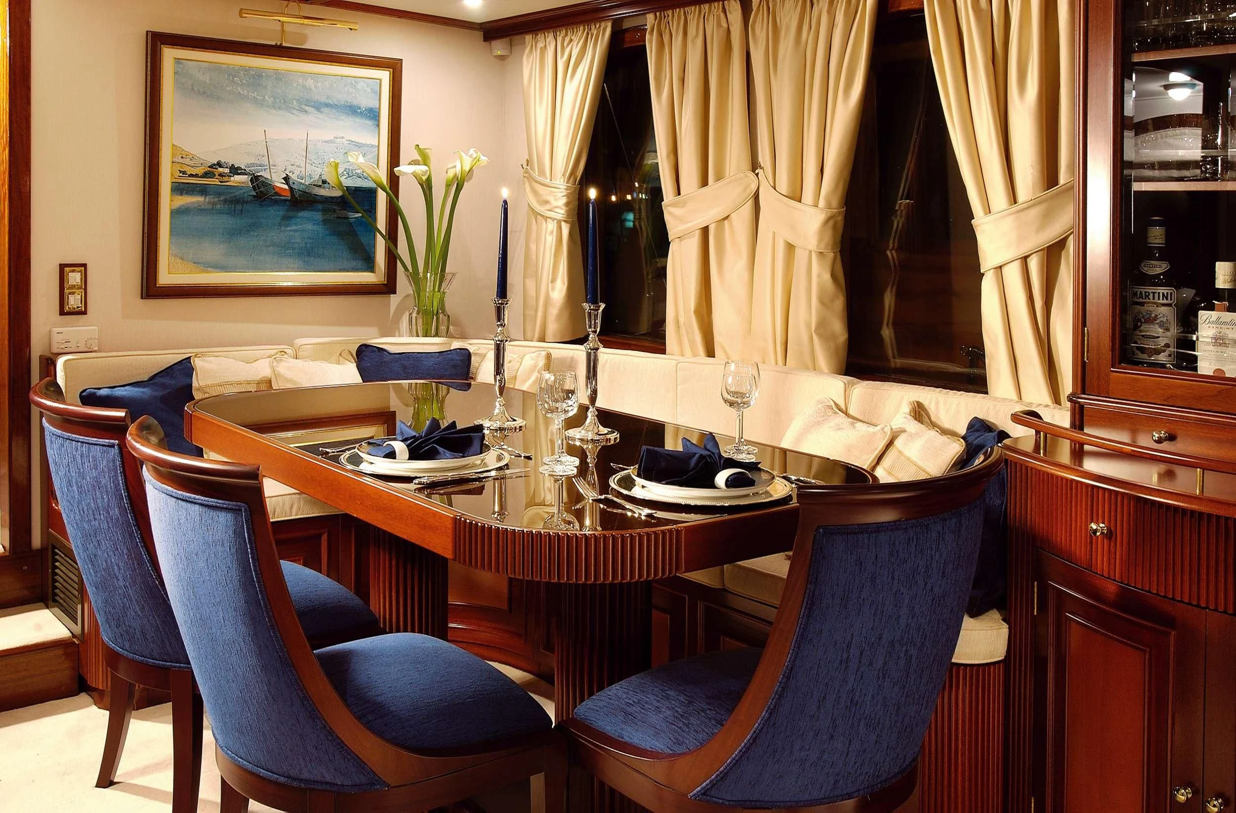 a dining table with blue chairs aboard LIANA H Yacht for Charter