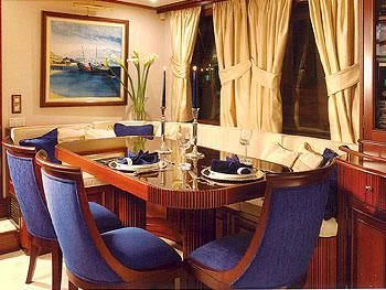 a table with chairs and a vase on it aboard LIANA H Yacht for Charter