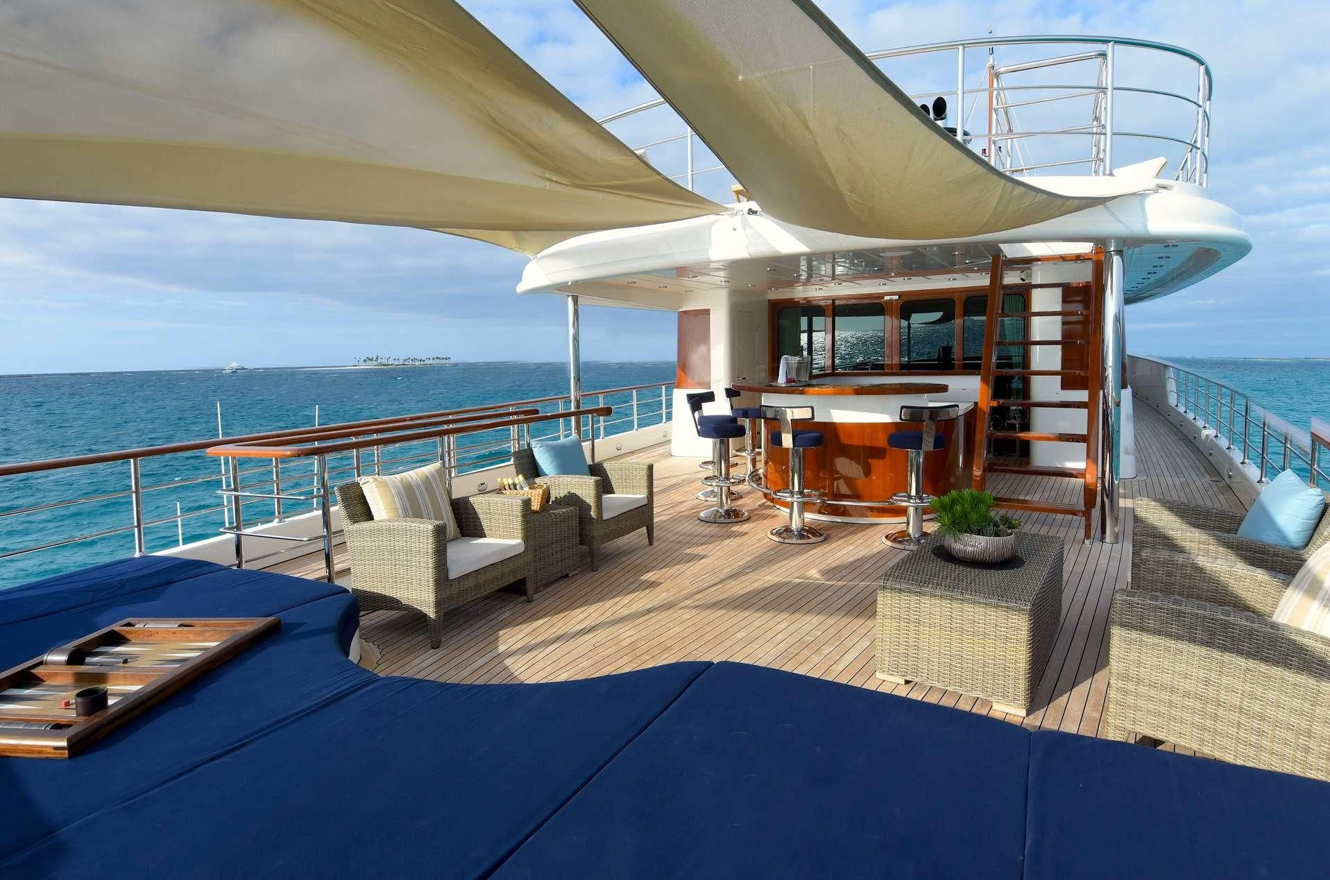 a deck with a pool and a deck with a view of the ocean aboard OMNIA 1 Yacht for Sale