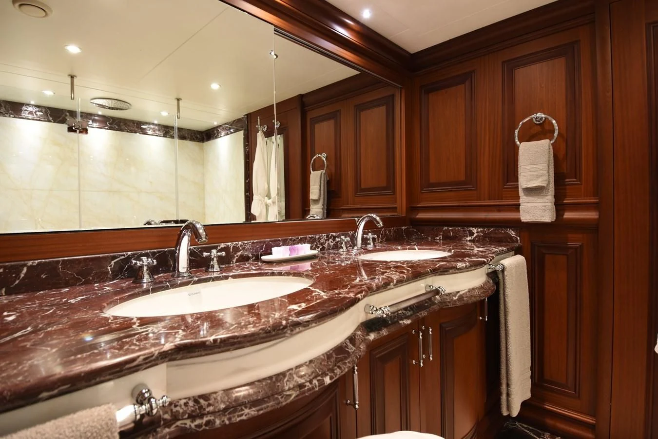 a bathroom with a countertop sink and wooden cabinets aboard OMNIA 1 Yacht for Sale
