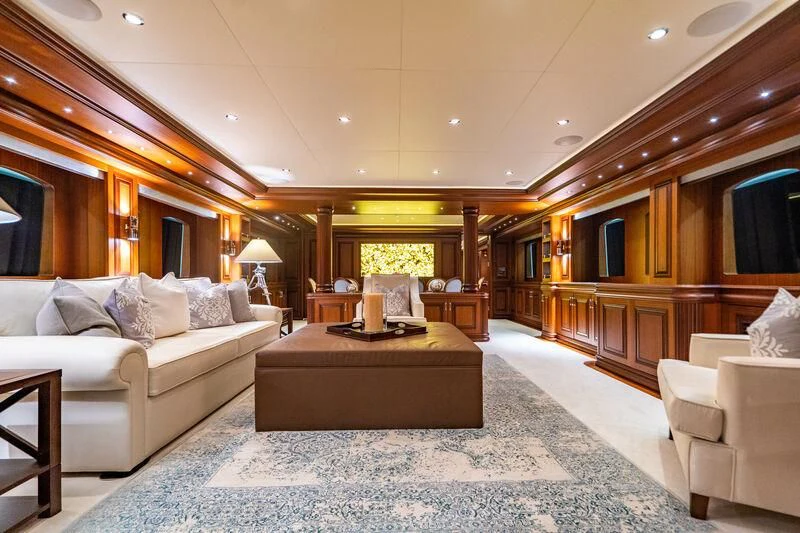 a large living room with a large white couch and a large chandelier aboard OMNIA 1 Yacht for Sale