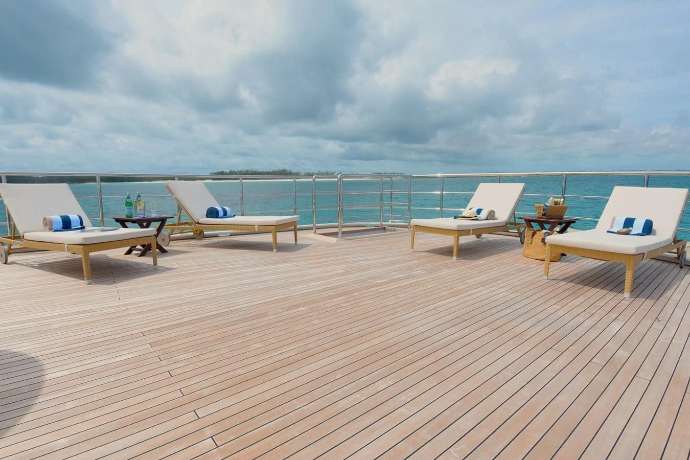 a deck with chairs and tables on it aboard OMNIA 1 Yacht for Sale