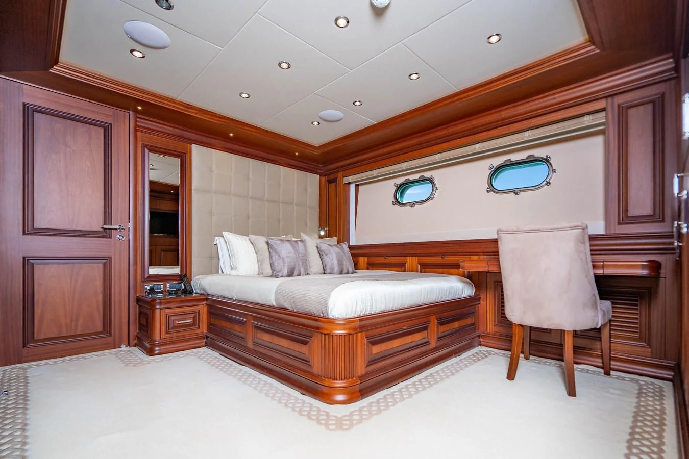 a bedroom with a bed and a chair aboard OMNIA 1 Yacht for Sale