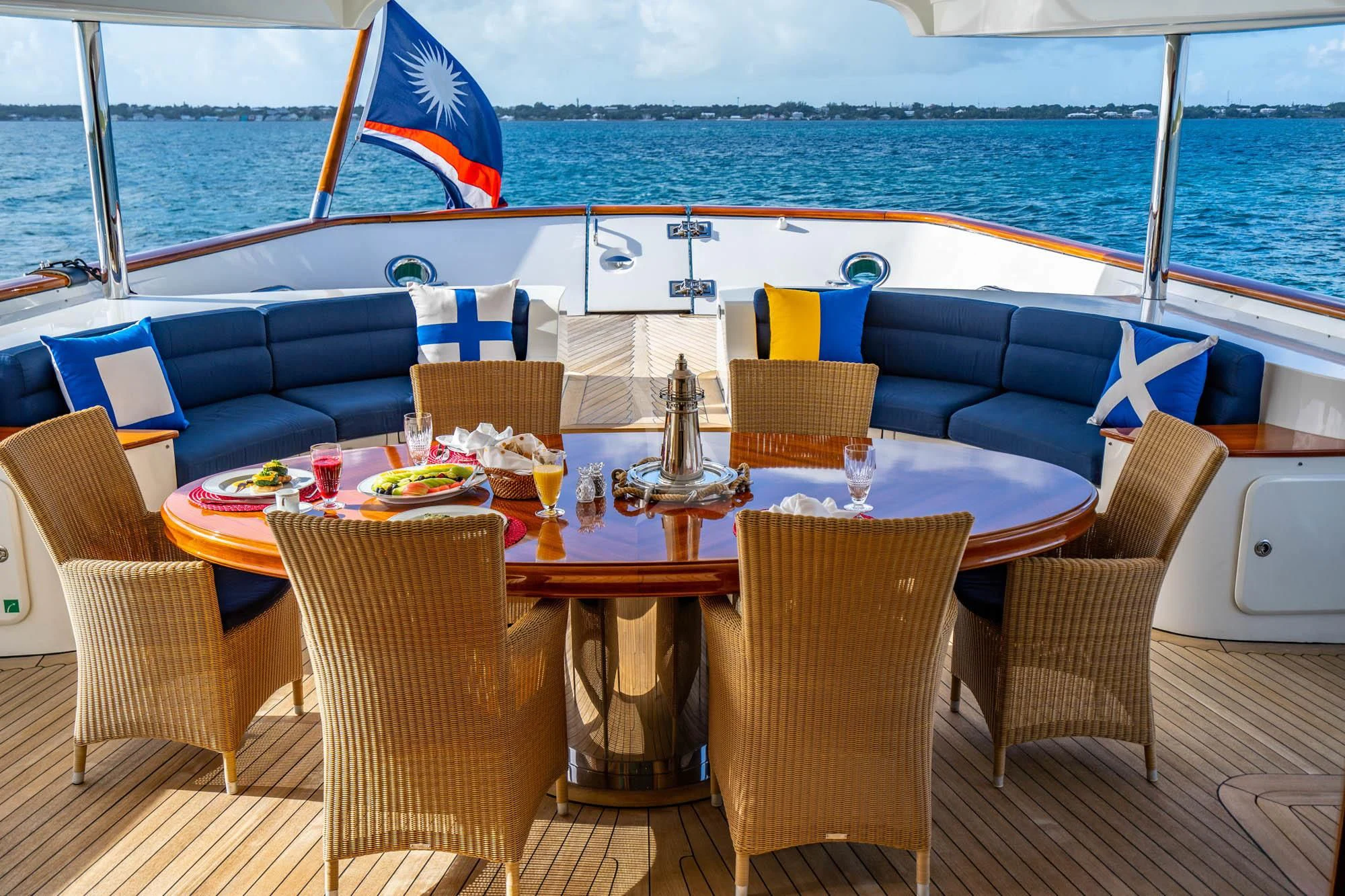 a table set for a meal on a deck overlooking the ocean aboard OMNIA 1 Yacht for Sale