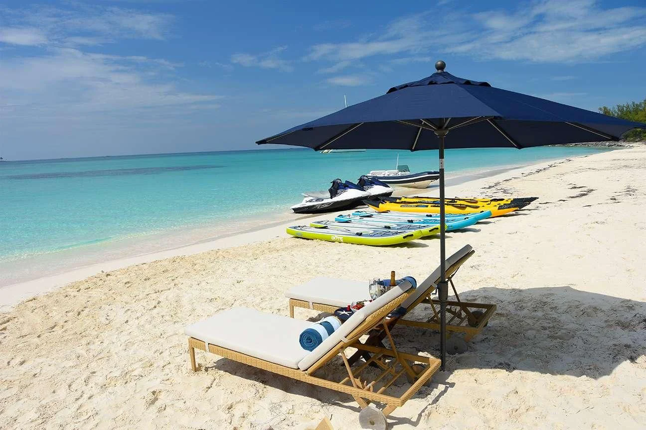 a beach with boats and umbrellas aboard OMNIA 1 Yacht for Sale