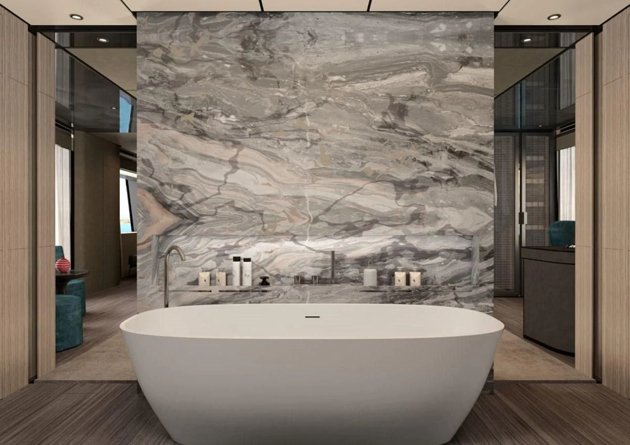 a large white bathtub in a room with a large stone wall aboard HORIZON Yacht for Sale
