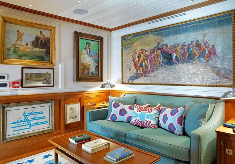 a living room with a couch and paintings on the wall aboard MESERRET II Yacht for Sale