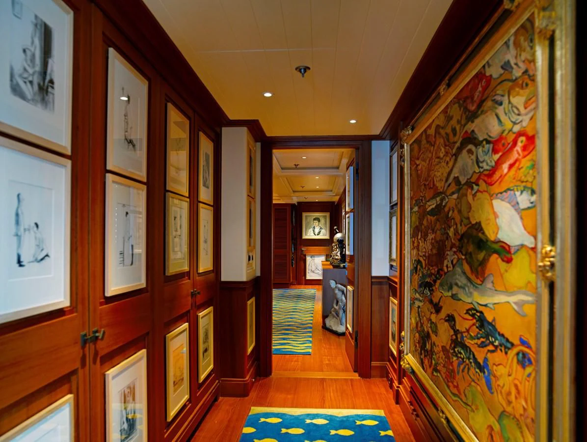 a hallway with paintings on the walls aboard MESERRET II Yacht for Sale