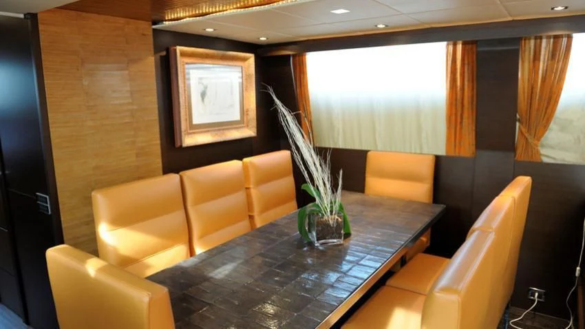 a room with a table chairs and a vase with flowers in it aboard ANDEA Yacht for Sale