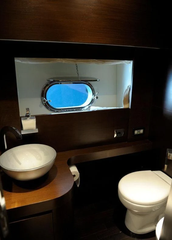 a bathroom with a round mirror aboard ANDEA Yacht for Sale