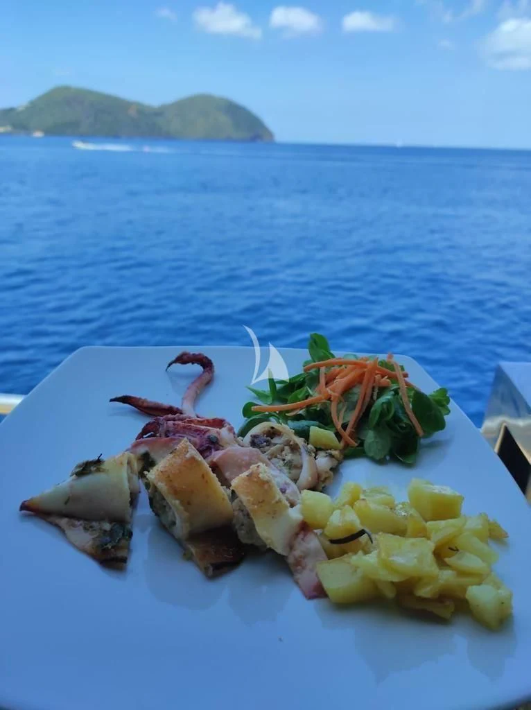 a plate of food on a beach aboard ANDEA Yacht for Sale