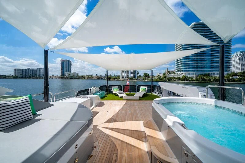 a deck with a pool and a city in the background aboard RING-N-WET Yacht for Sale