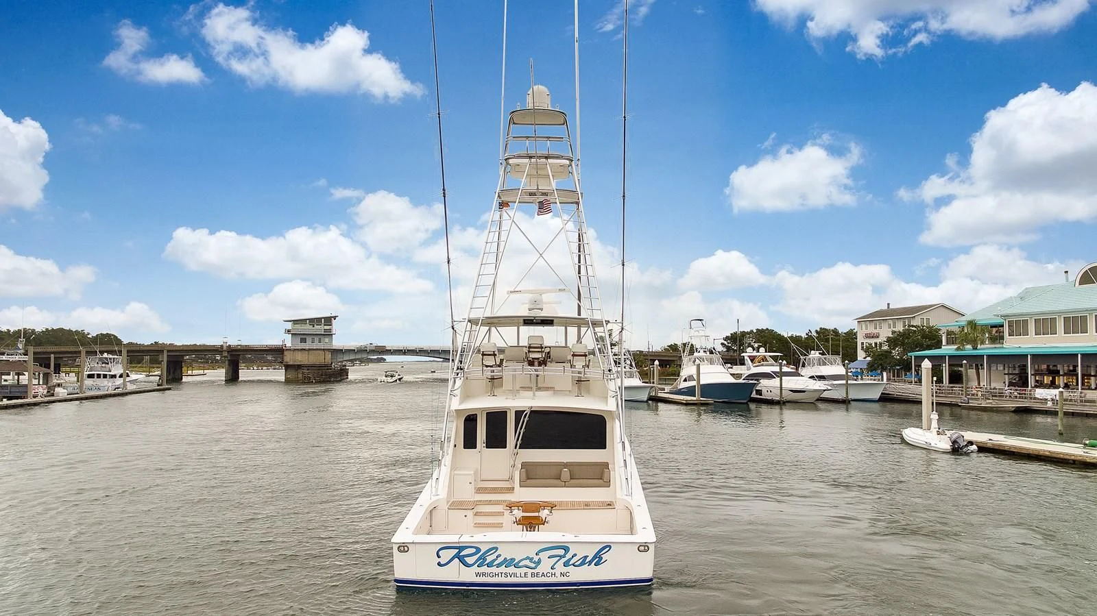 a white boat in a harbor aboard RHINO FISH Yacht for Sale