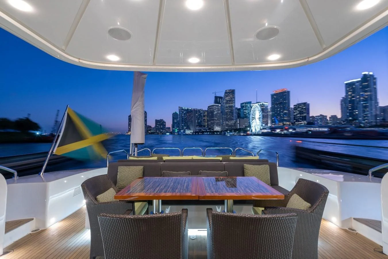 a table and chairs on a deck overlooking a city aboard ENCORE Yacht for Sale