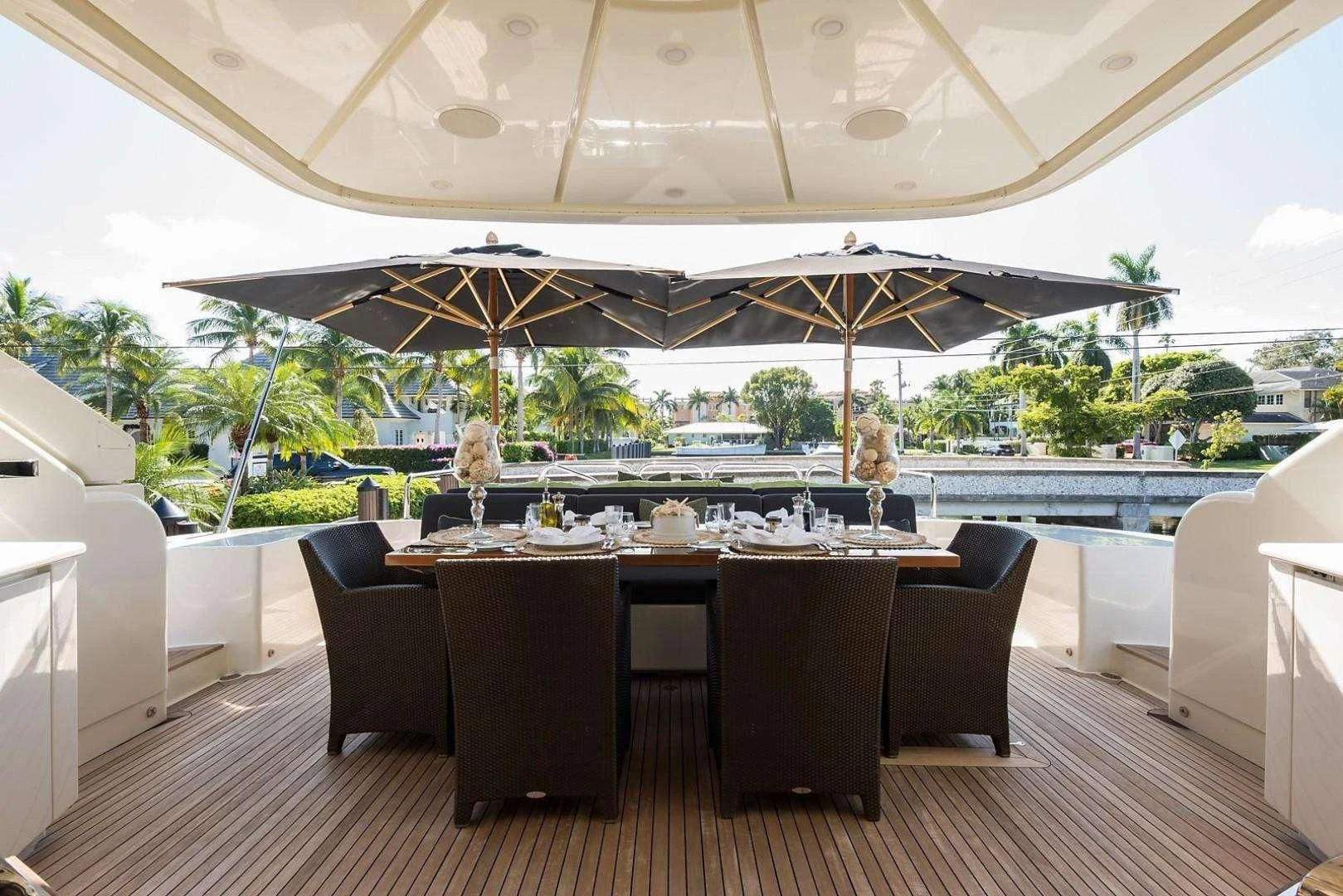a large room with a table and chairs and umbrellas aboard ENCORE Yacht for Sale
