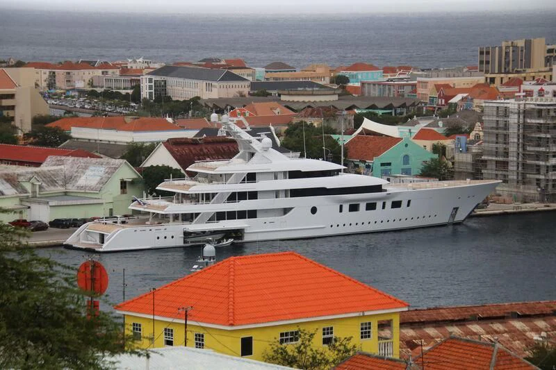 a large white boat in a harbor aboard BLISS Yacht for Sale