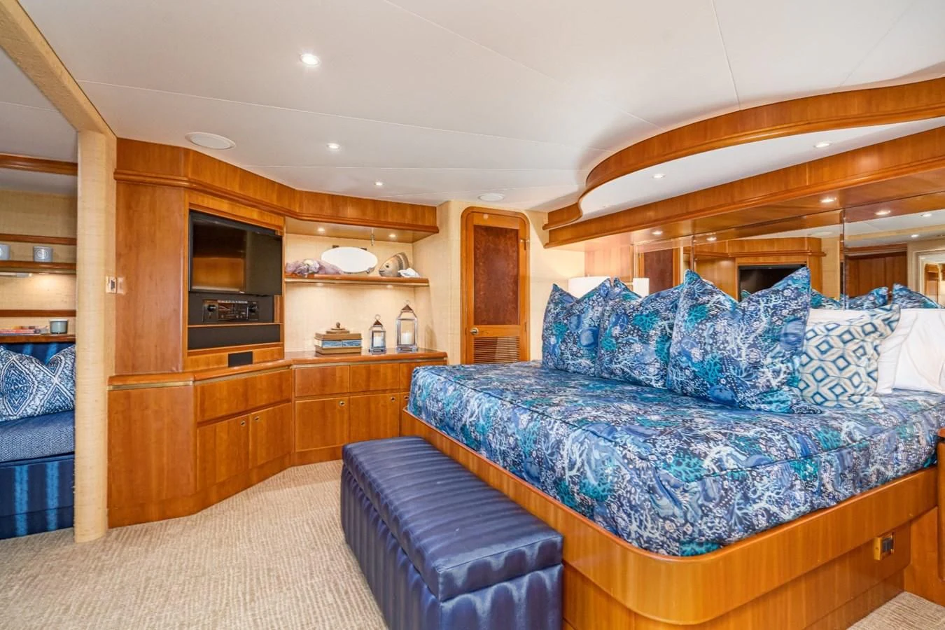 a bedroom with a bed and a wood cabinet aboard MAHANA Yacht for Sale