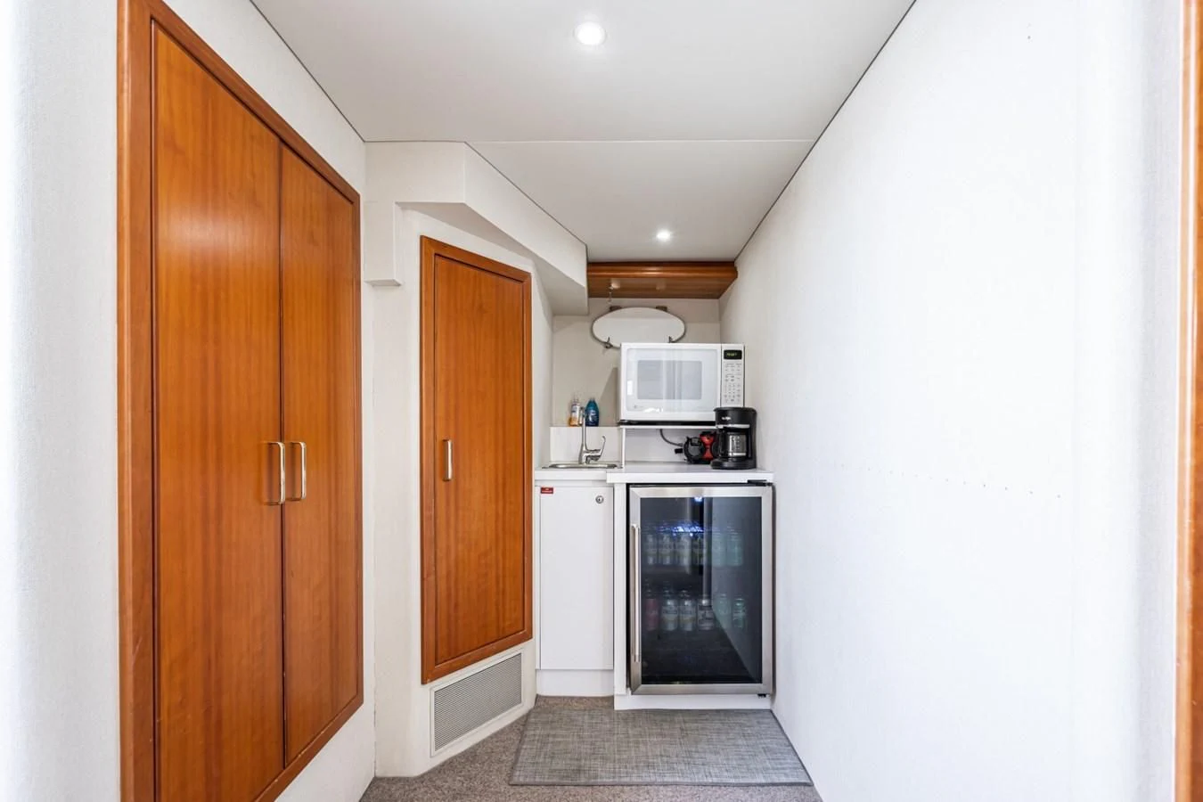 a kitchen with a microwave oven and wooden cabinets aboard MAHANA Yacht for Sale