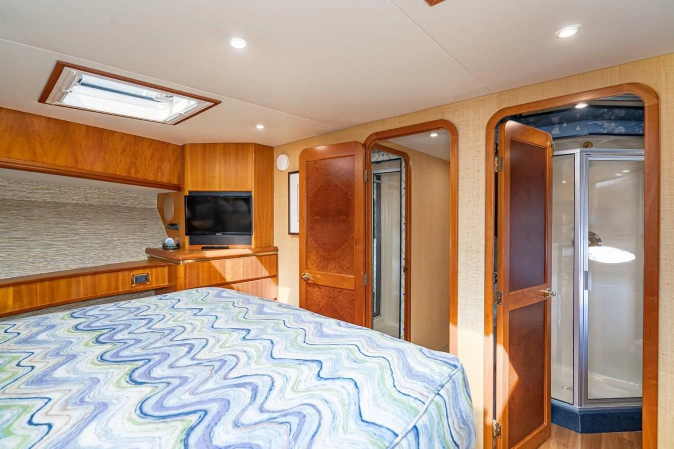 a bedroom with a bed and a television aboard MAHANA Yacht for Sale