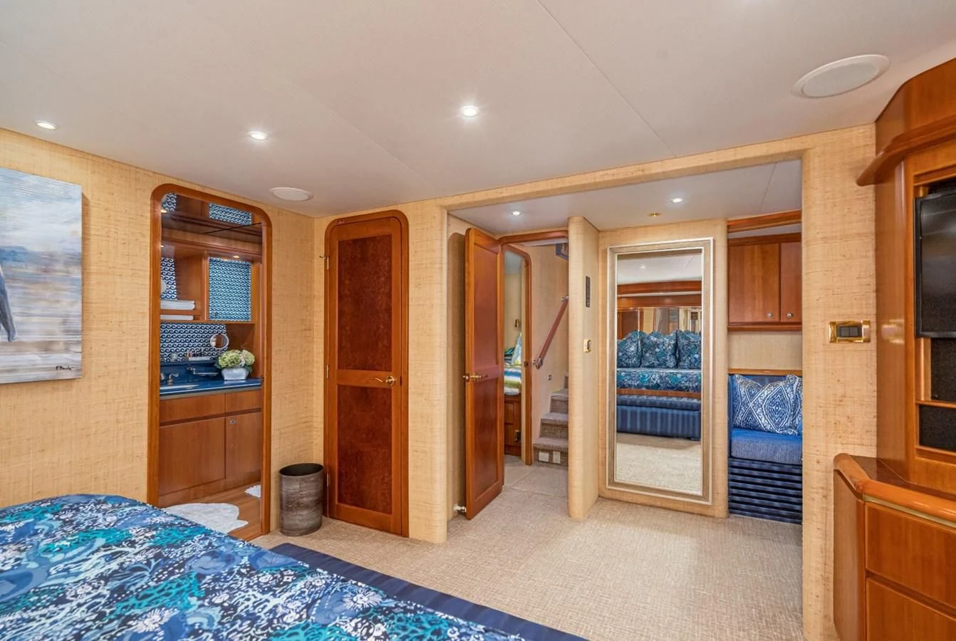a bedroom with wood cabinets aboard MAHANA Yacht for Sale