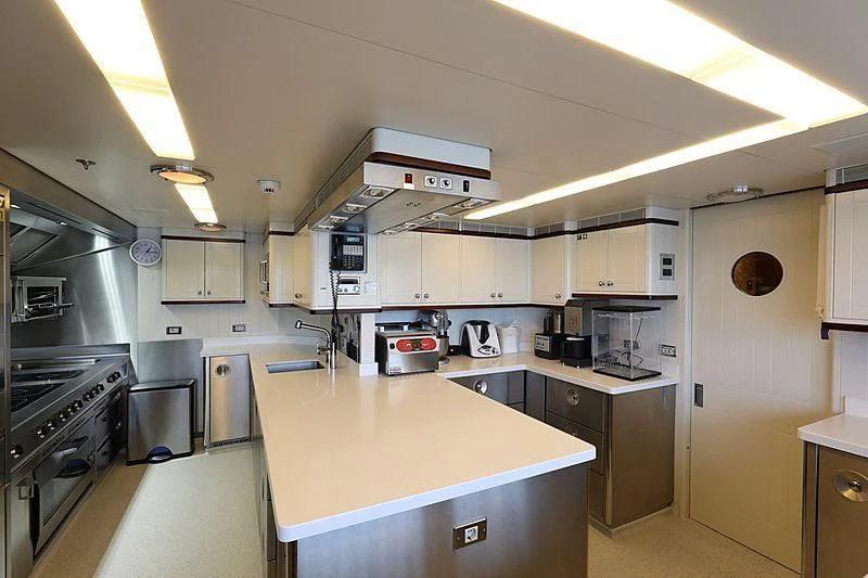 a kitchen with white cabinets aboard PREDICTION Yacht for Sale