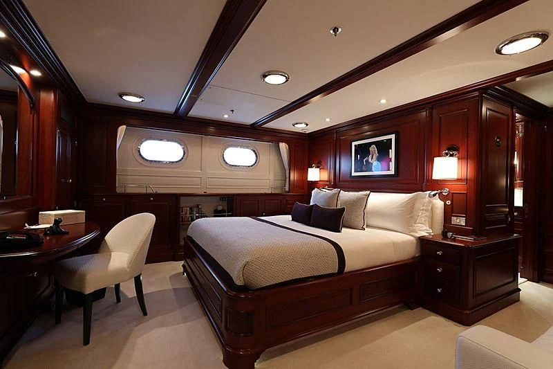 a hotel room with a bed and desk aboard PREDICTION Yacht for Sale