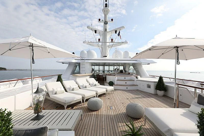 a deck with lounge chairs and umbrellas and a large white satellite dish aboard PREDICTION Yacht for Sale
