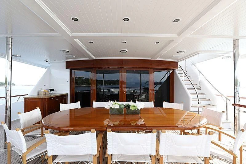 a dining table with white chairs aboard PREDICTION Yacht for Sale
