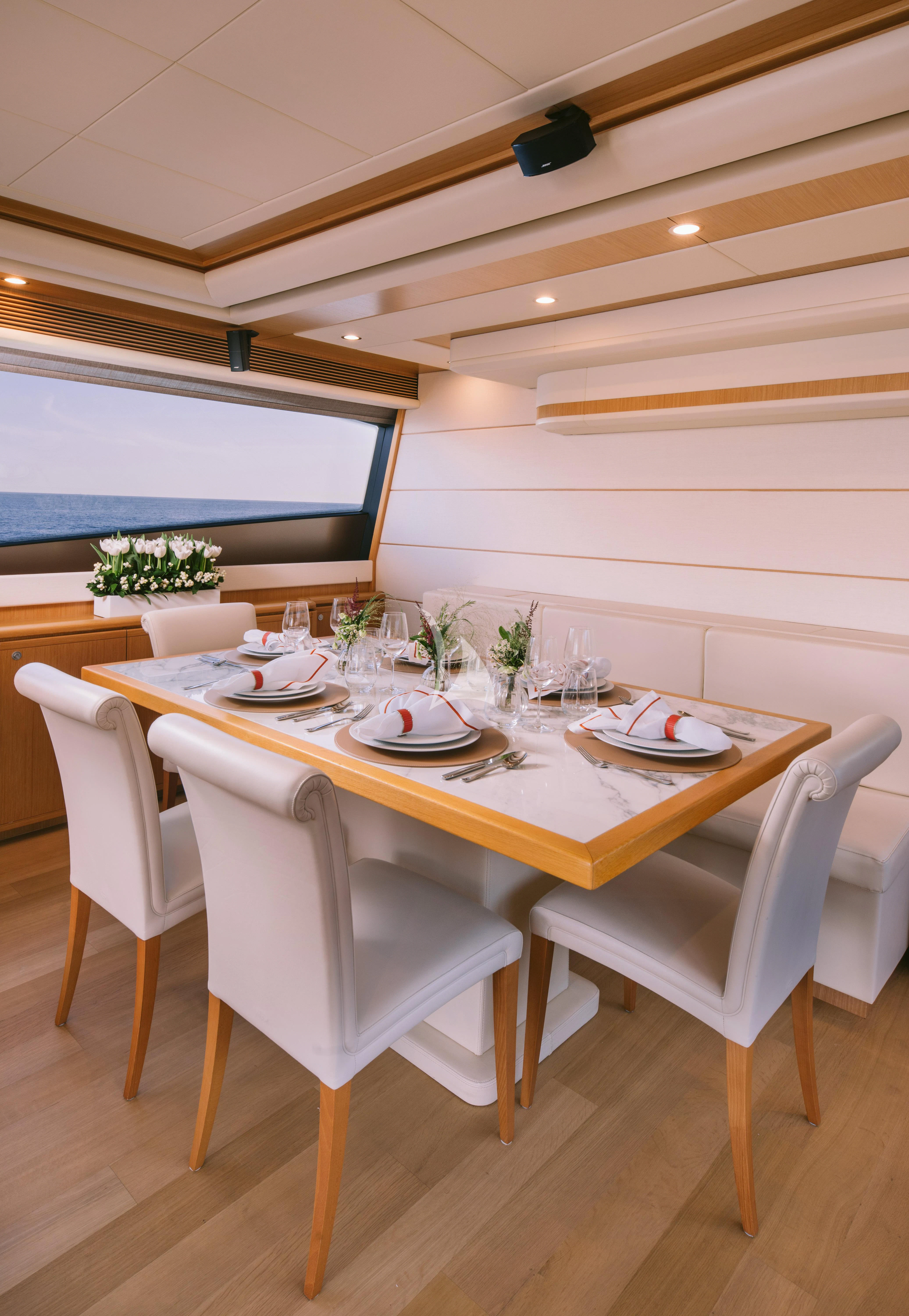 a table set with plates and glasses aboard MELI Yacht for Charter