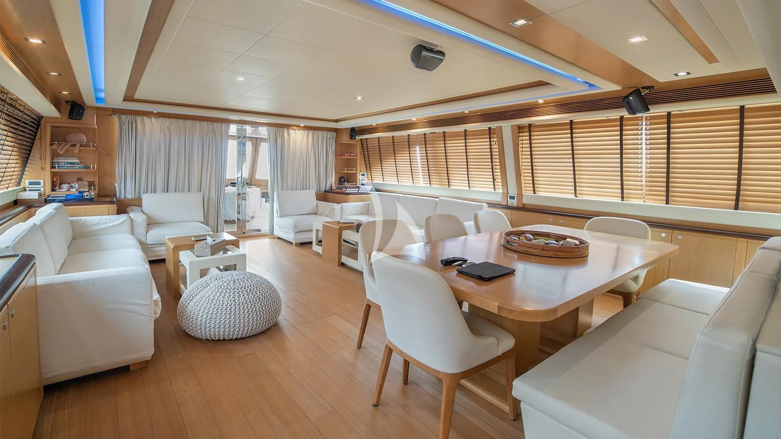 a room with a table chairs and a couch aboard MELI Yacht for Charter