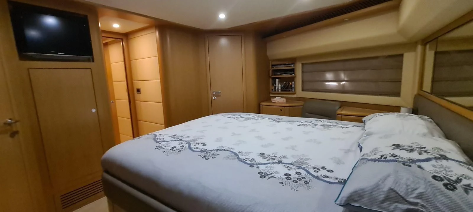 a bed with a television on the wall aboard MELI Yacht for Charter
