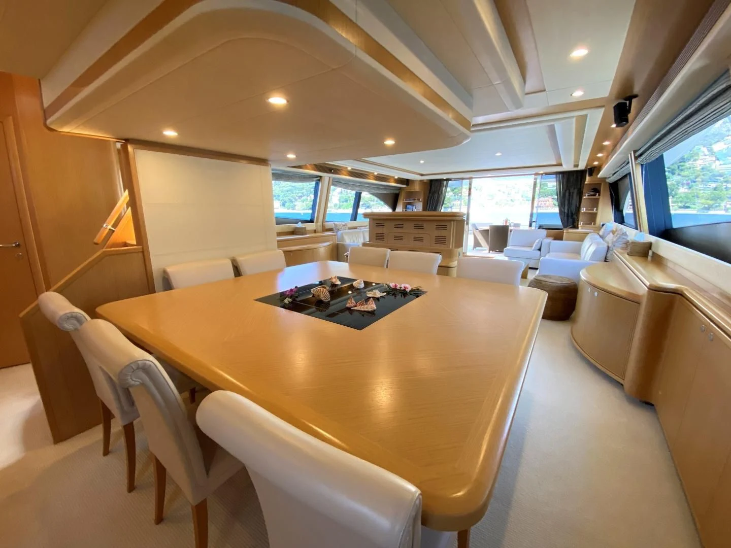 a room with a table chairs and a couch aboard MELI Yacht for Charter